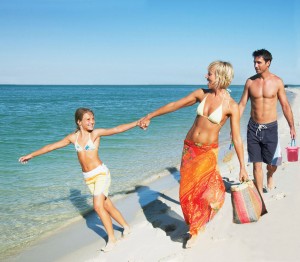 Mother and father walking on beach with son and daughter (7-9)